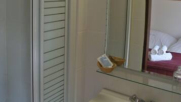 Une salle de bain avec des toilettes, un lavabo et un miroir.