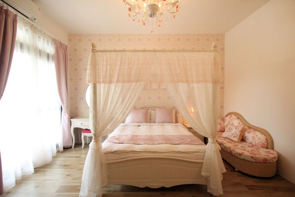 A bedroom with a four-poster bed, a bedside table, and a chair. - Chi Ya B&B (Hualien City)