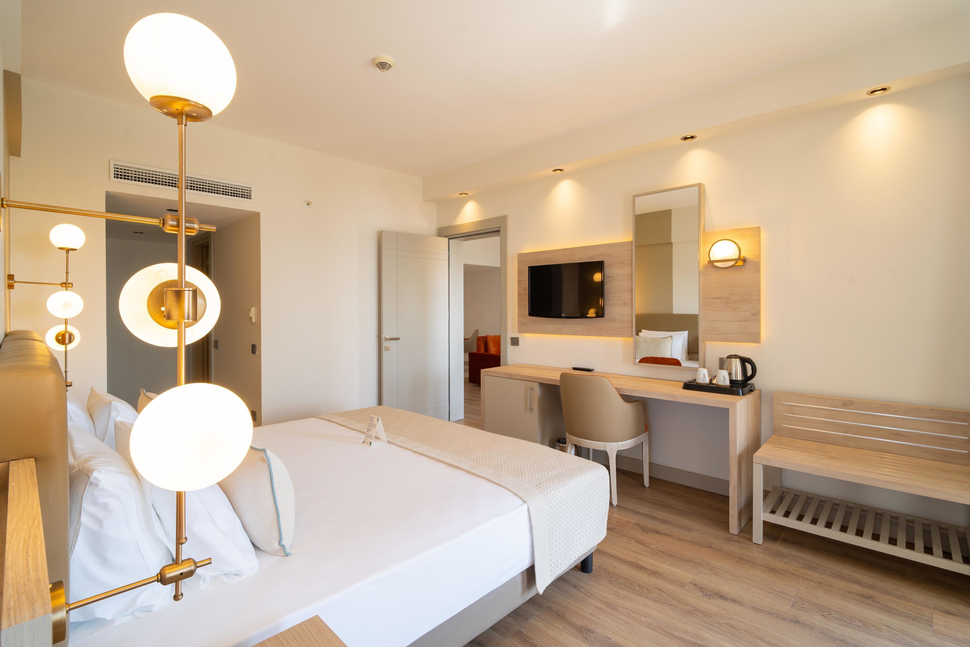 Una habitación de hotel con cama, escritorio, silla y un banco.