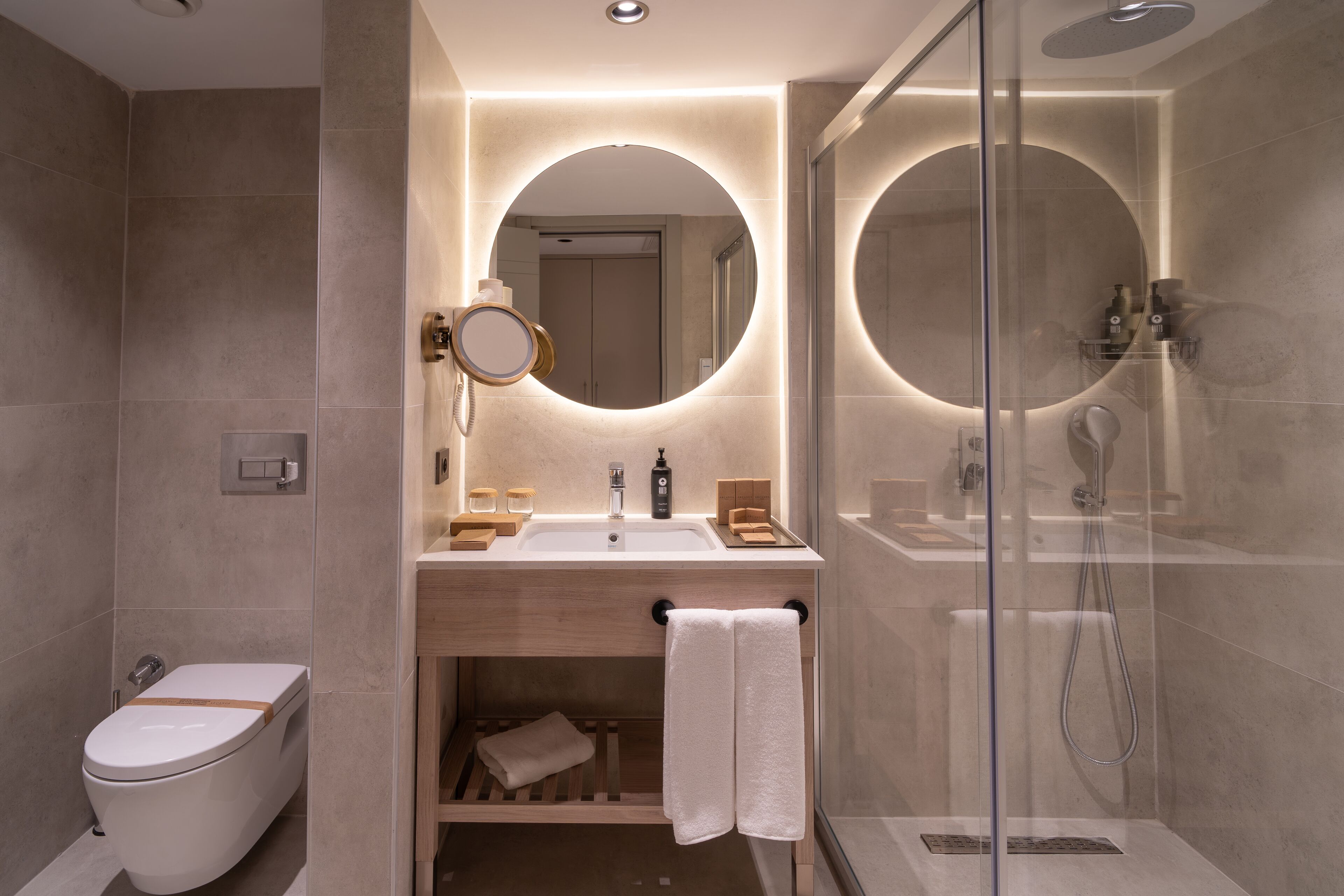 A modern bathroom with a toilet, sink, and shower.