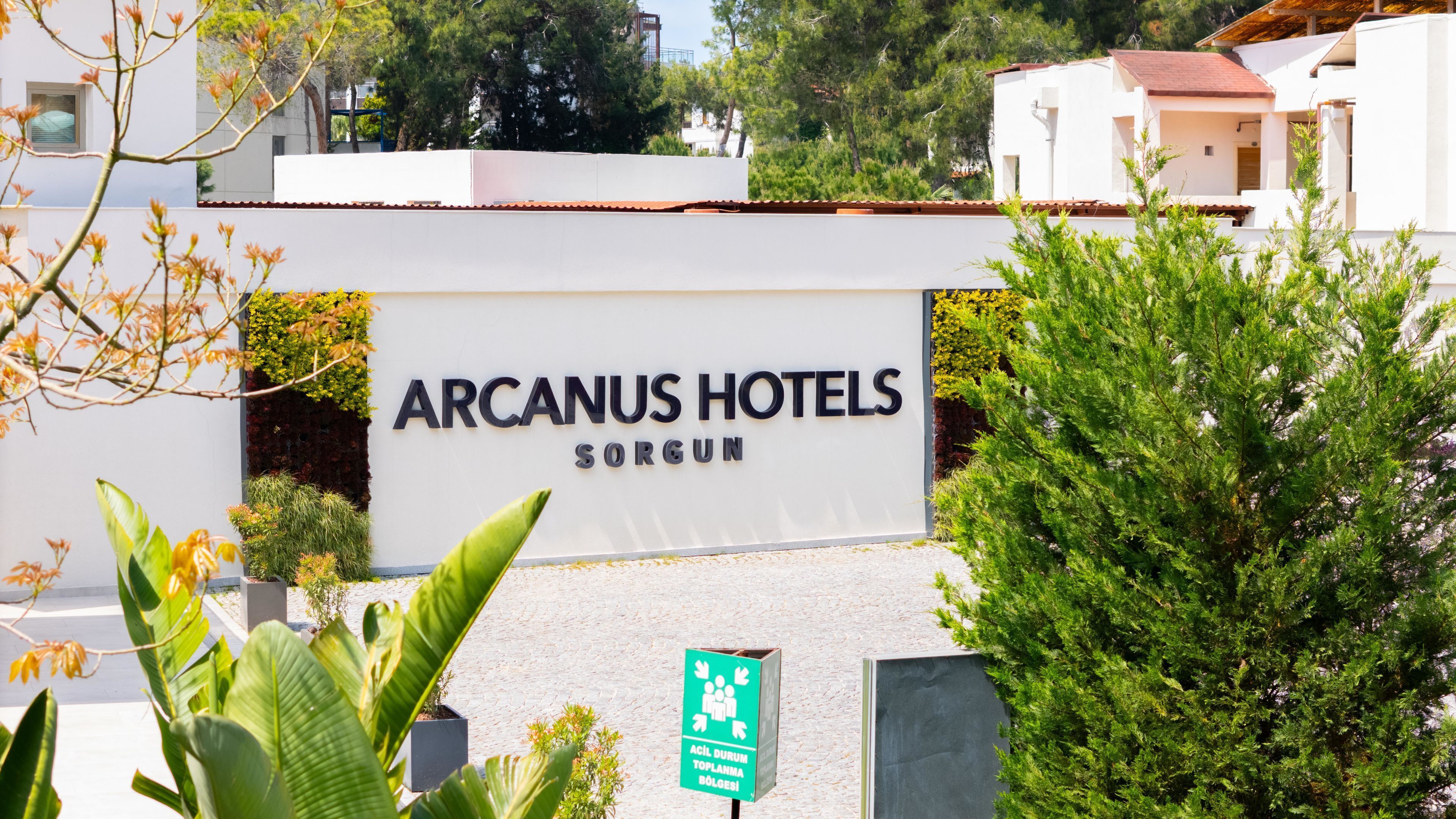 Señal de Arcanuš Hotels en Sorgun, con vista despejada al acceso y la vegetación circundante.