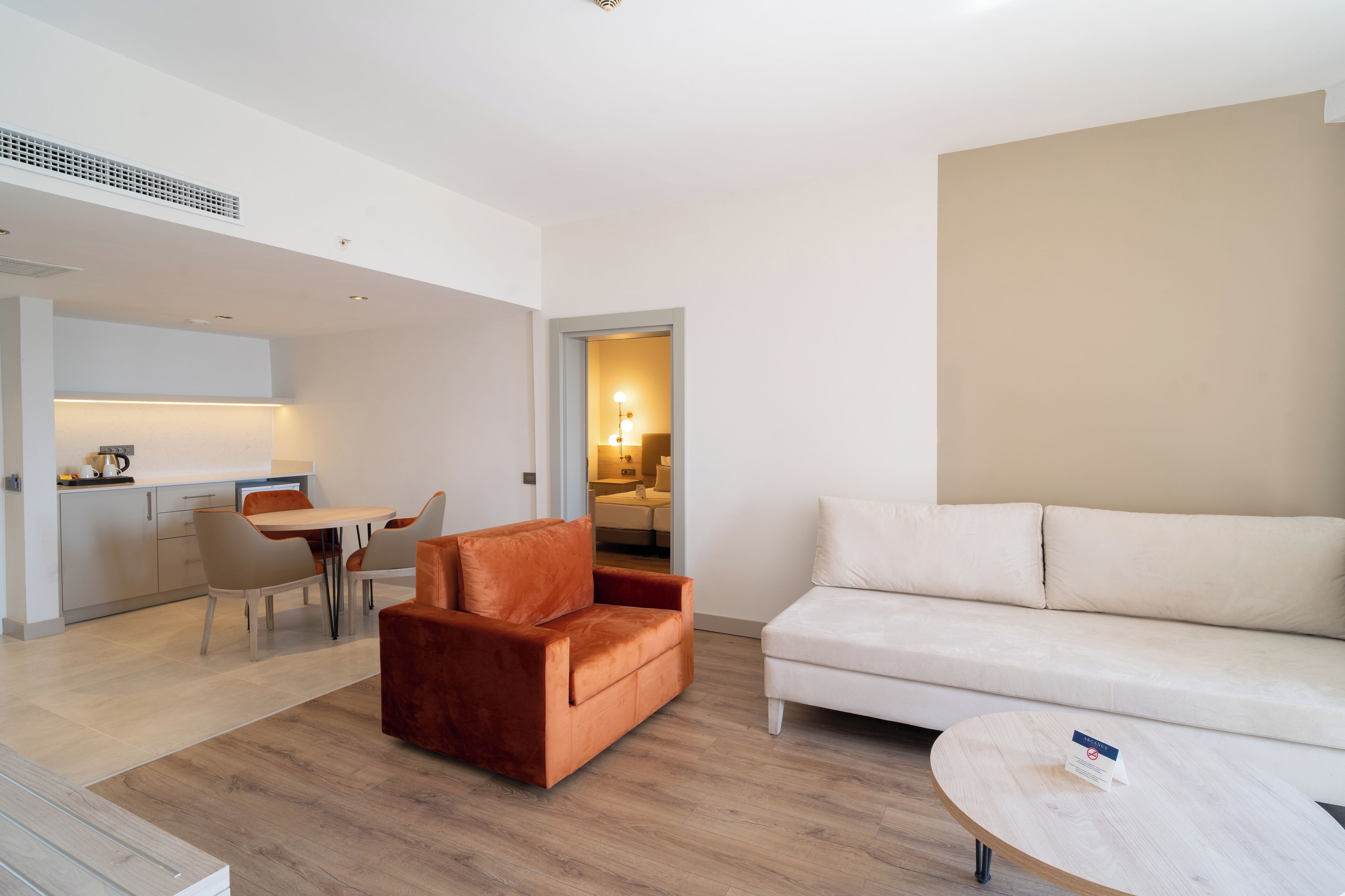 Una sala de estar moderna con un sofá, una mesa de centro y un comedor con sillas y una mesa.