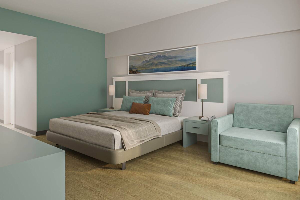 Um quarto moderno com cama, mesas de cabeceira, uma cadeira e um quadro na parede.
