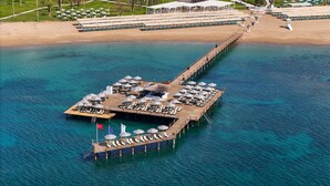 An overwater resort with a pier, sun loungers, umbrellas, and a flag. - Arcanus Hotels Sorgun - All Inclusive (Manavgat)