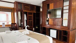 A hotel room with a bed, wooden wardrobe, and a television. - Maison Saiko Angkor Boutique (Siem Reap)
