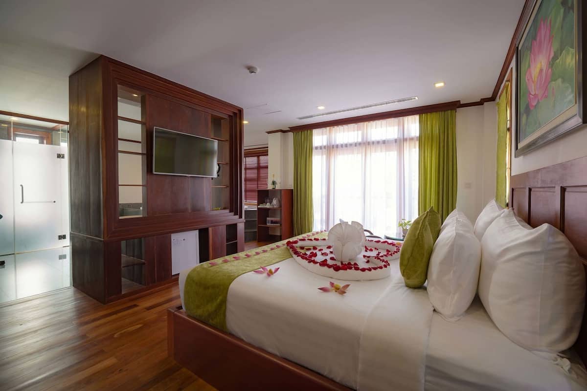 Habitación de hotel con cama, televisión, armario y escritorio.