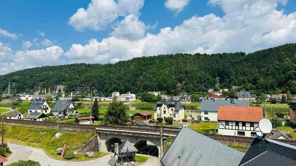 A town with a railway line, houses, and a hill in the background.