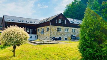 A two-story building with a stone facade and a dark wooden upper section.