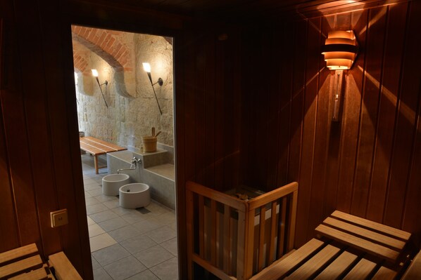 A wooden interior with a bench, a stone wall, and a bench with a light fixture.