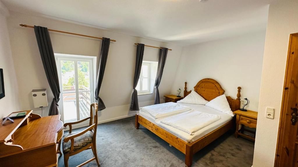 A bedroom with a double bed, a desk, and a chair.