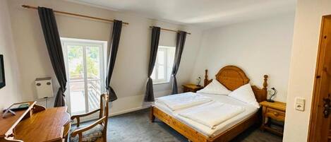 A bedroom with a double bed, a desk, and a chair.