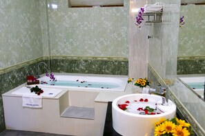 Un baño con bañera, lavamanos y espejo.
