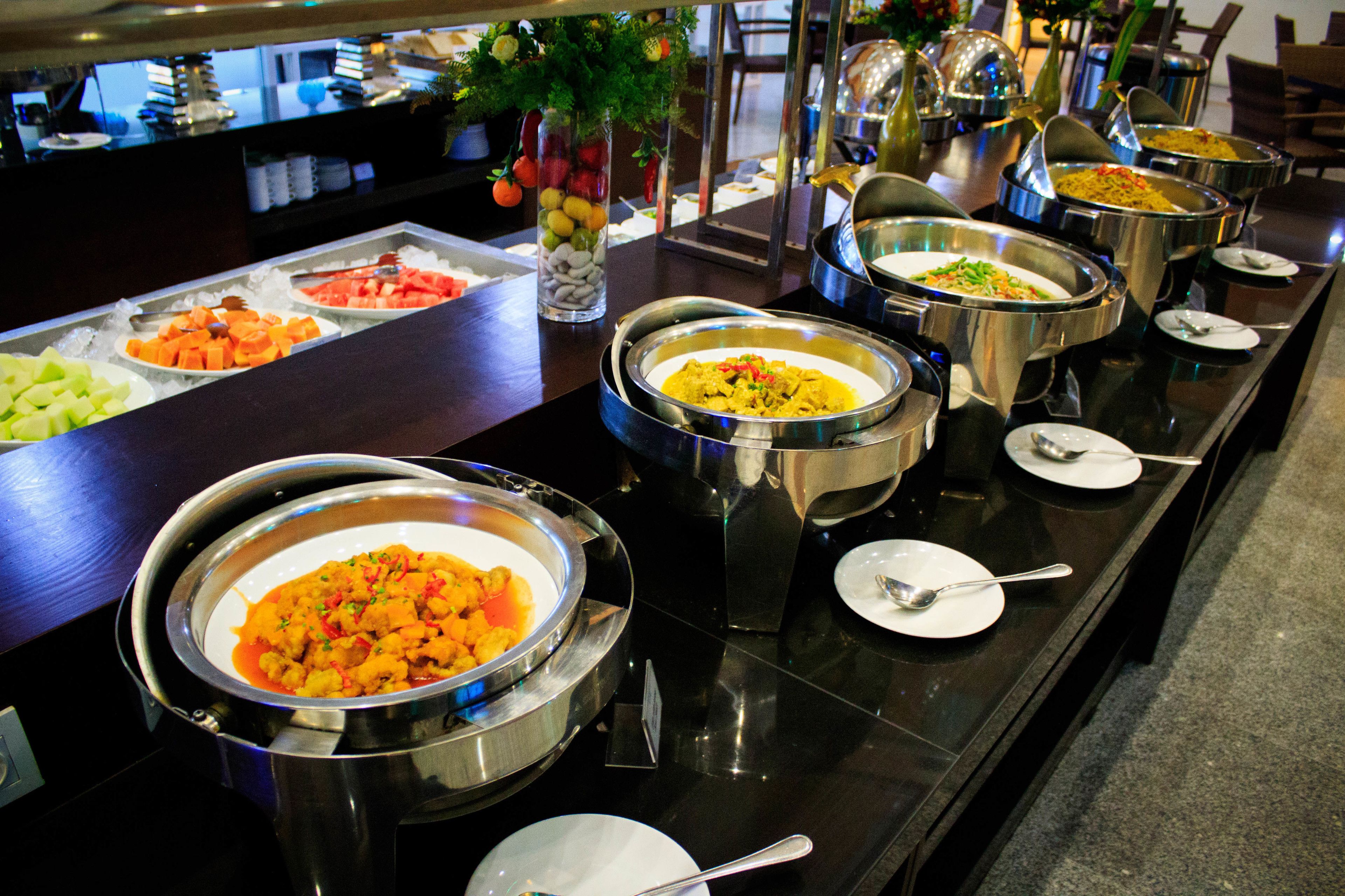 Un buffet proposant une variété de plats et d’ustensiles de service.