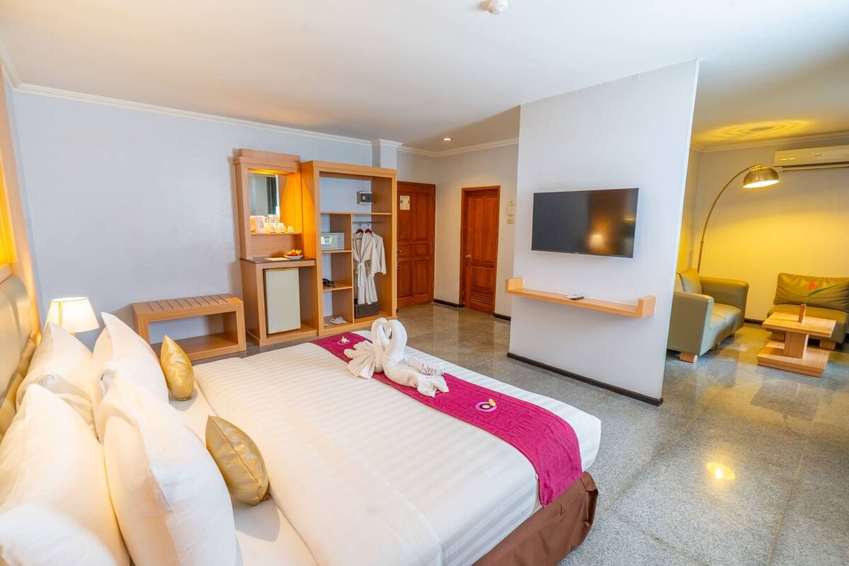 Una habitación de hotel con cama, escritorio, televisor y baño.