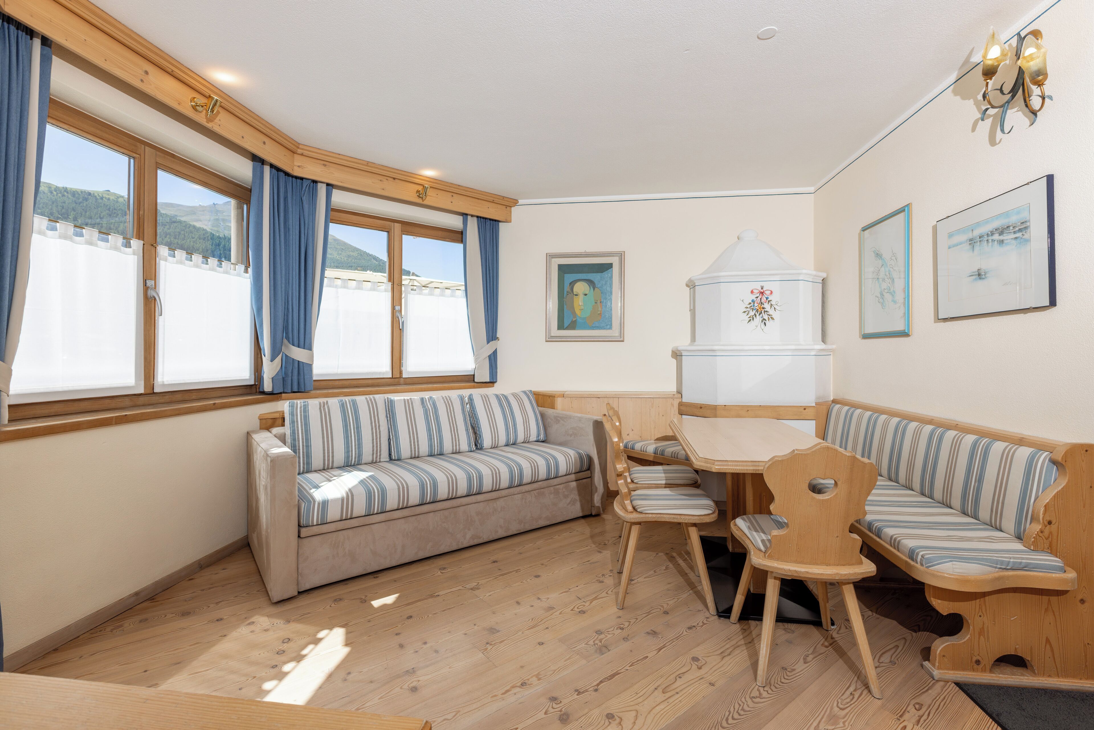 Un cuarto acogedor con sofá, sillas, una mesa y vistas al exterior.