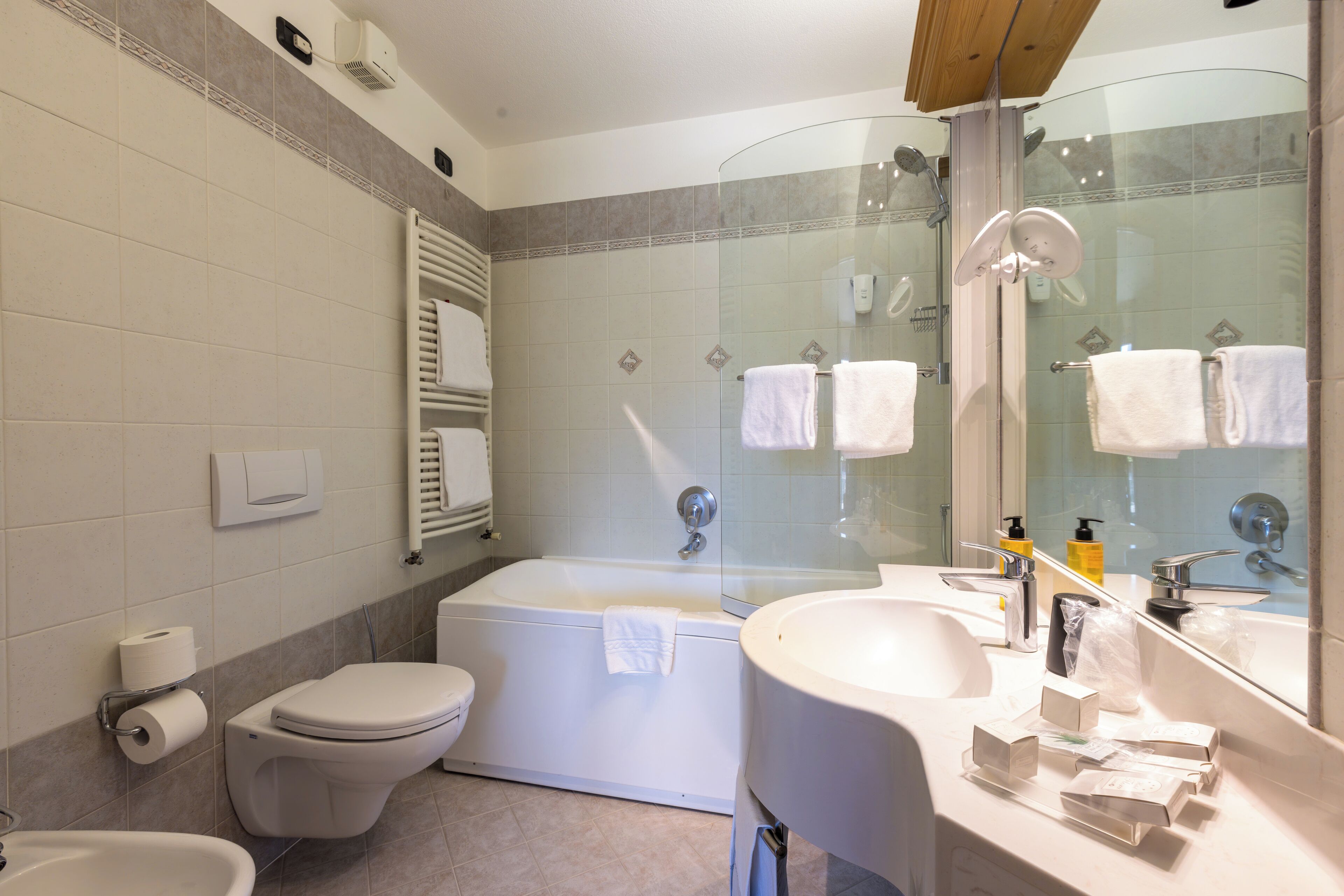 A modern bathroom with a toilet, bathtub, and sink.
