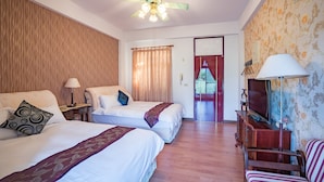 A hotel room with two beds, a ceiling fan, a TV, and a wooden floor. - Hualien Tour B&B (Xincheng)
