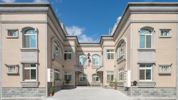 A symmetrical building with a central entrance, large windows, and a clear sky. - Hualien Tour B&B (Xincheng)