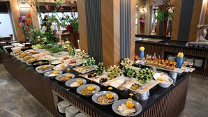 A buffet with various food items and a decorative plant arrangement. - Side Yesiloz Hotel - All inclusive (Manavgat)