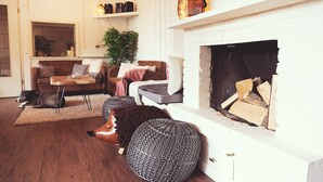 Een gezellige woonkamer met een open haard, een bank, een salontafel en een hond.