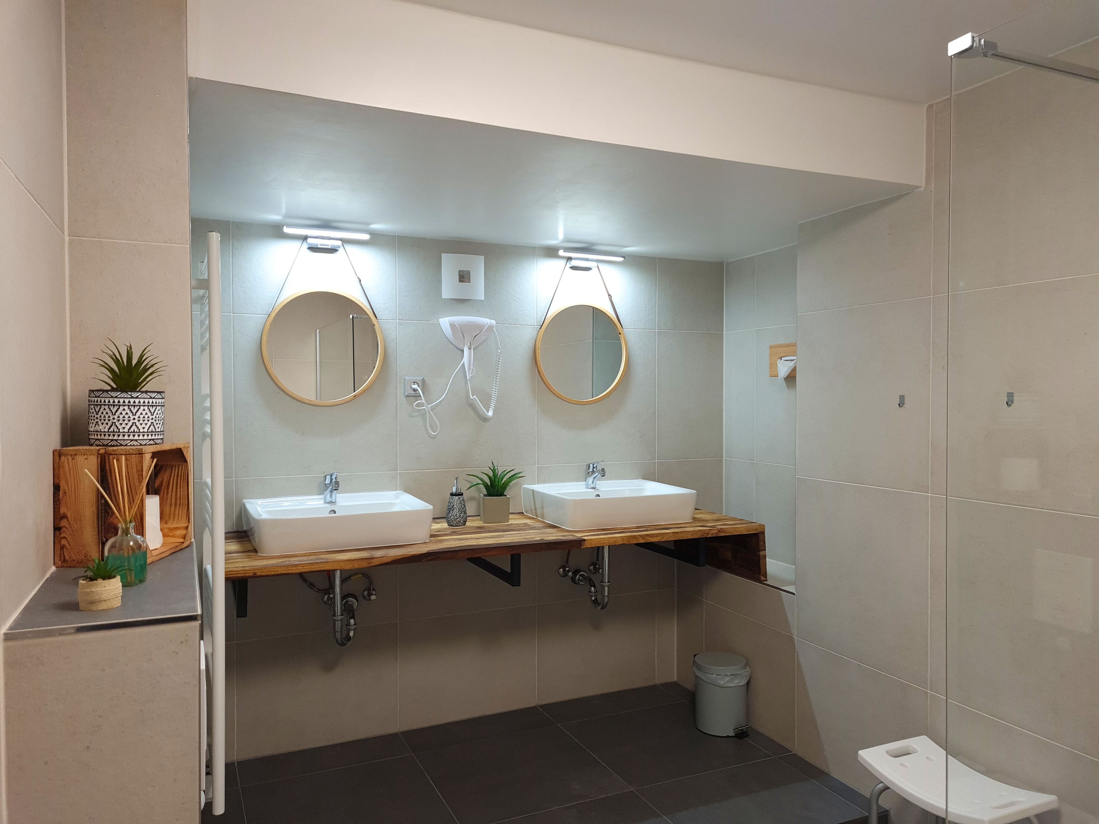 Un baño moderno con dos lavamanos, un espejo y un inodoro.