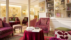A well-appointed lounge area with plush seating, a bookshelf, and a decorative wall. - Hôtel du Levant (Paris)