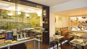 A dining area with tables, chairs, and a buffet counter with food and beverages. - Hôtel du Levant (Paris)