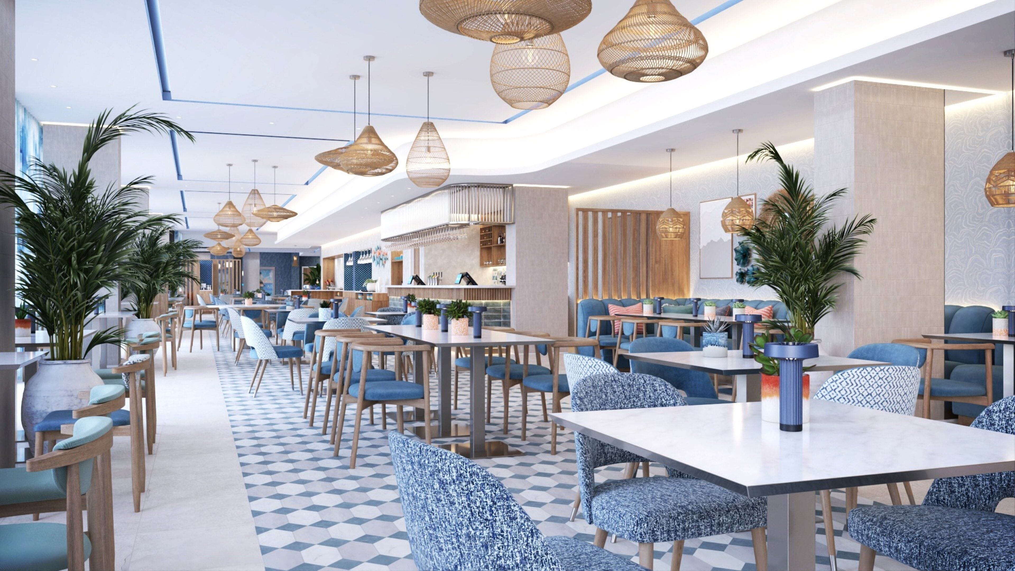 Un restaurante moderno con techos altos, iluminación colgante y una variedad de opciones de asientos, incluyendo mesas y cabinas.