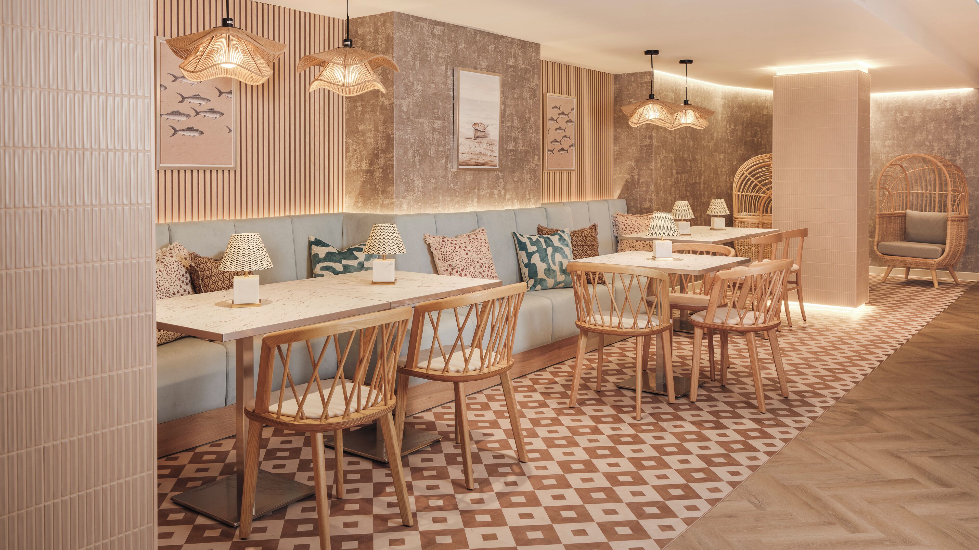 Un restaurant doté de mobilier en bois, d’un éclairage suspendu et d’un revêtement de sol à motifs.