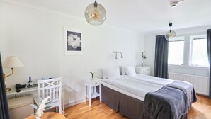 A bedroom with a large bed, bedside tables, a desk, and a chair. - Mullsjö Hotell och konferens (Mullsjö)