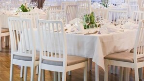 A dining area with white tables and chairs, chandeliers, and large windows. - Mullsjö Hotell och konferens (Mullsjö)