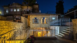 Edifici de pedra amb una escala, un balcó i una barana de ferro forjat.