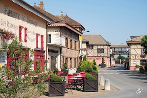 Un café restaurante con terraza y estilo arquitectónico europeo tradicional.