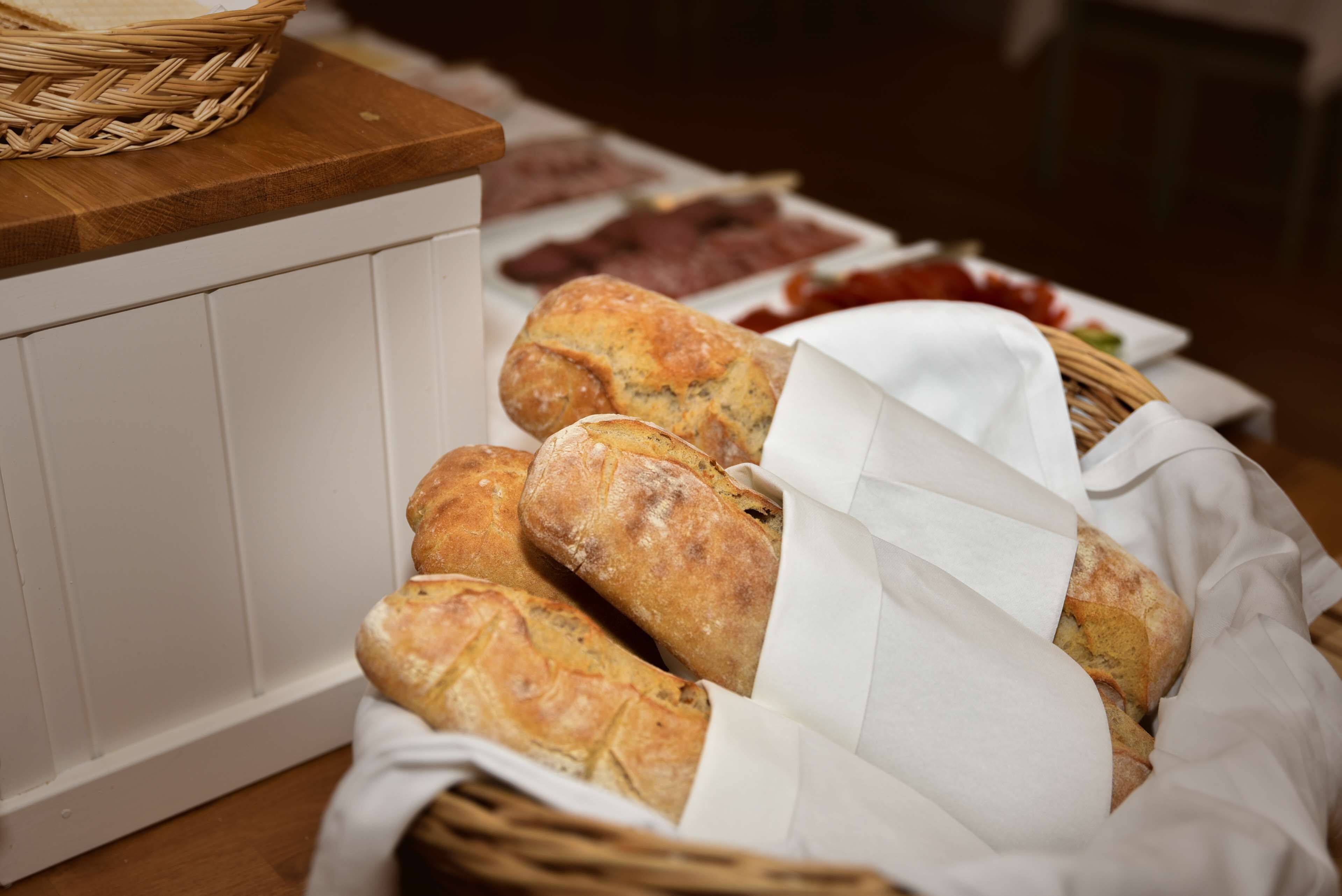 Un panier de baguettes sur une table en bois.