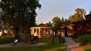 A playground with a slide and climbing structures, a gazebo, and a wooden building with a porch. - Hotel Ullinge, Sure Hotel Collection by Best Western (Eksjo)