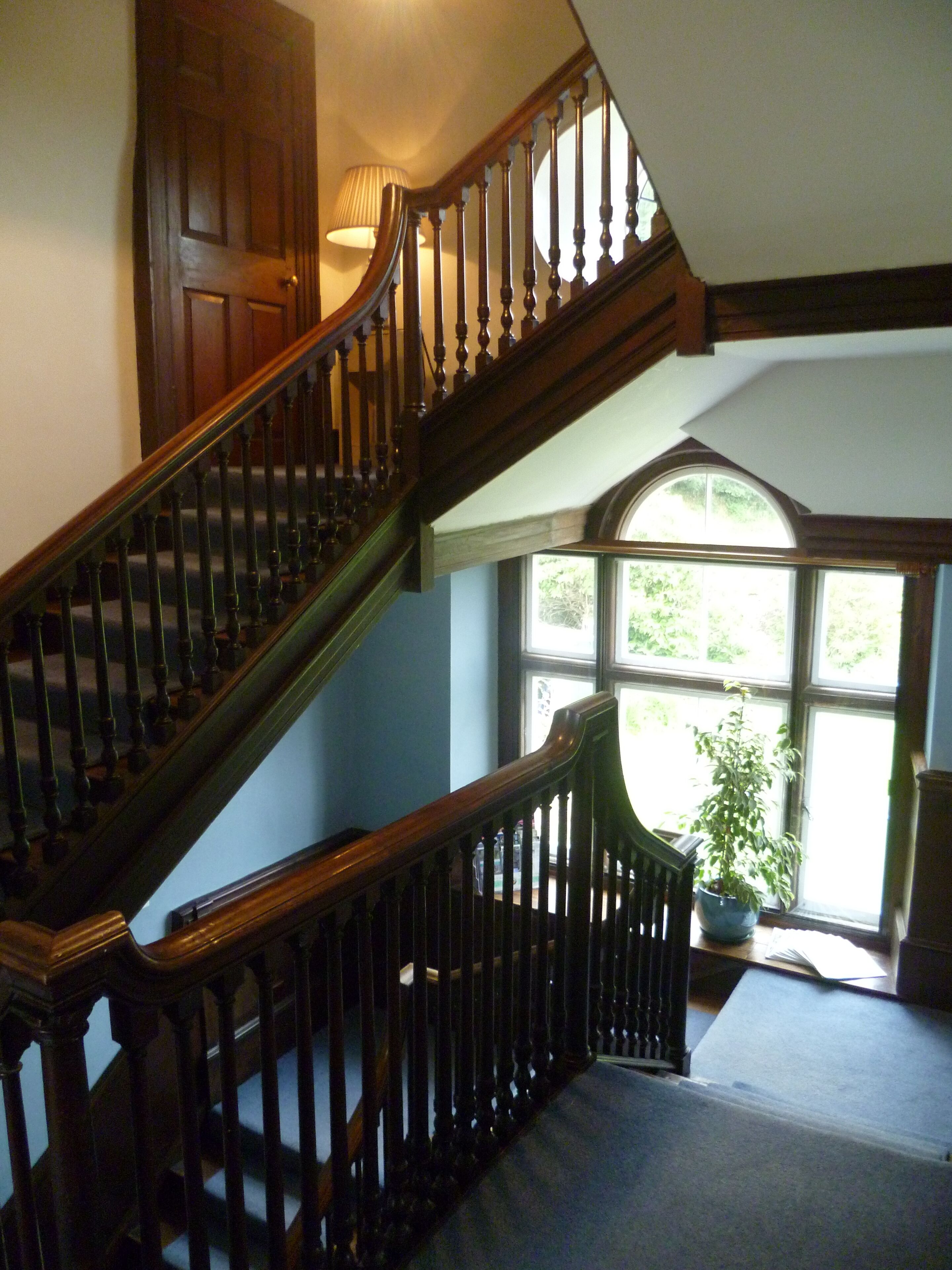 Un escalier en bois à la forme incurvée, menant à l’étage supérieur.