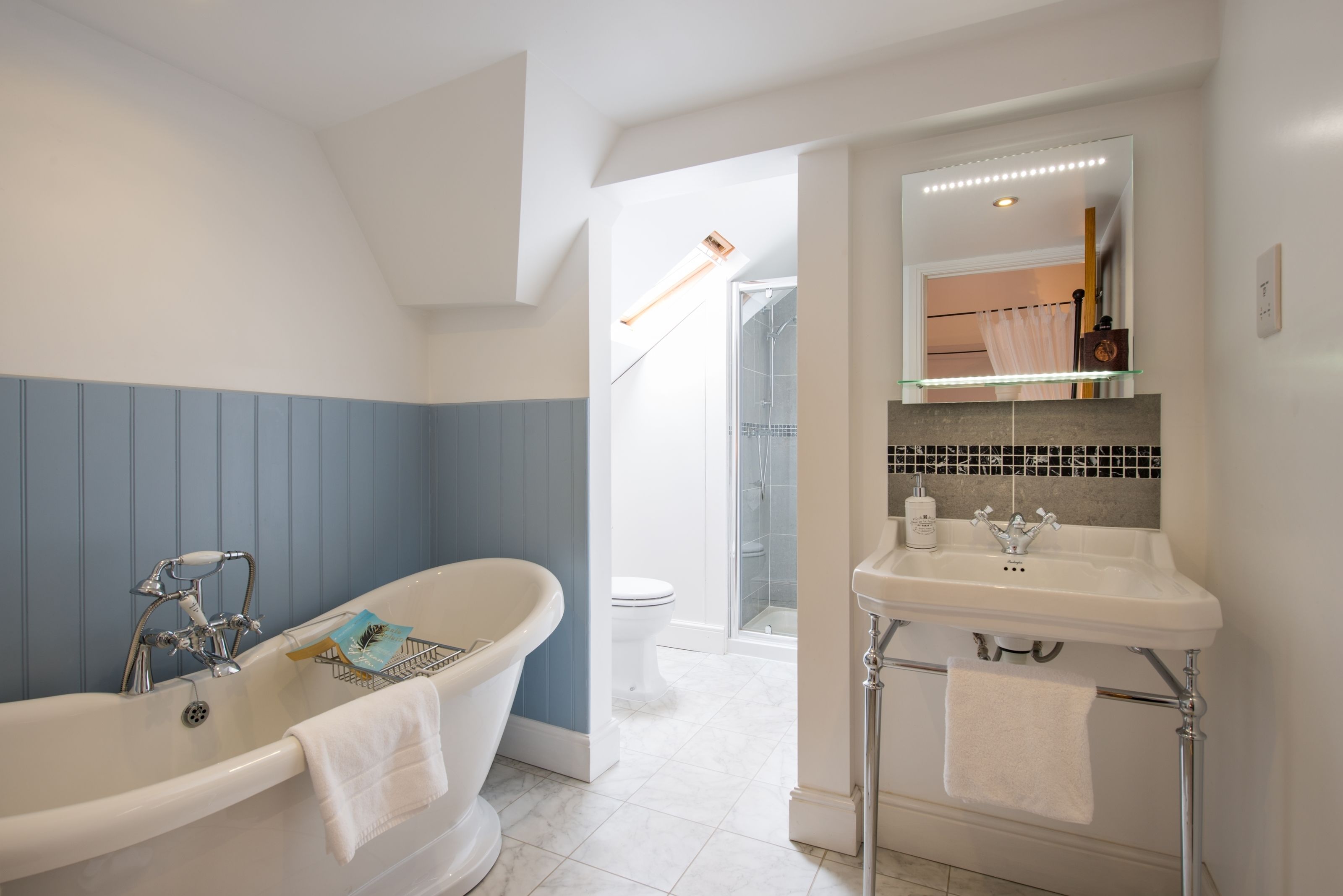 Une salle de bain avec une baignoire sur pieds, un lavabo et un miroir.