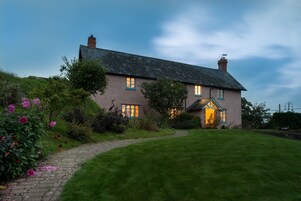 A two-story house with a paved driveway and a well-maintained lawn.