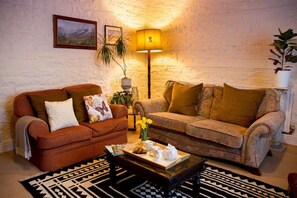 Una sala de estar acogedora con dos sofás, una mesa de centro y una lámpara.
