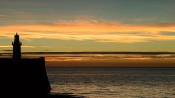 Silhouet van een vuurtoren voor een zonsondergang.