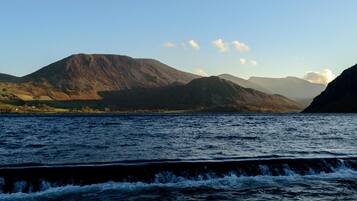 A lake with mountains in the background and waves in the foreground.