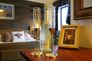 Una botella de Freixenet Prosecco sobre una mesa de madera con dos copas de champán.