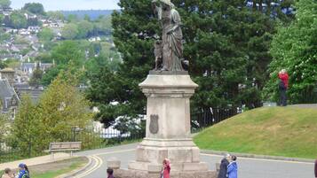 A statue on a pedestal with a town in the background.
