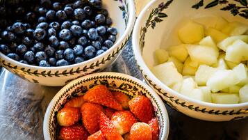 Three bowls with different fruits: blueberries, strawberries, and diced apples.