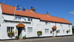 A white building with a red-tiled roof and the sign "ORCHARD LODGE". - Orchard Lodge & Wolds Restaurant (Scarborough)