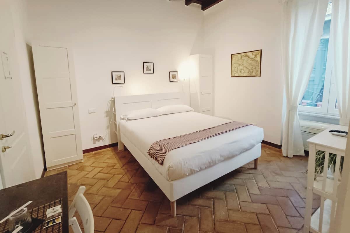 Un dormitorio con una cama, un escritorio y una silla. Hay tres cuadros en la pared.