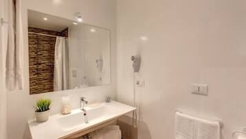 Uma casa de banho moderna com uma pia branca, um espelho, um secador de cabelo e um porta-toalhas.