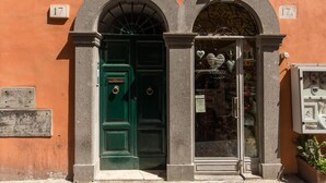 A building with a green door and a shop window displaying heart-shaped decorations. - Piccolo Trevi Suites (Rome)