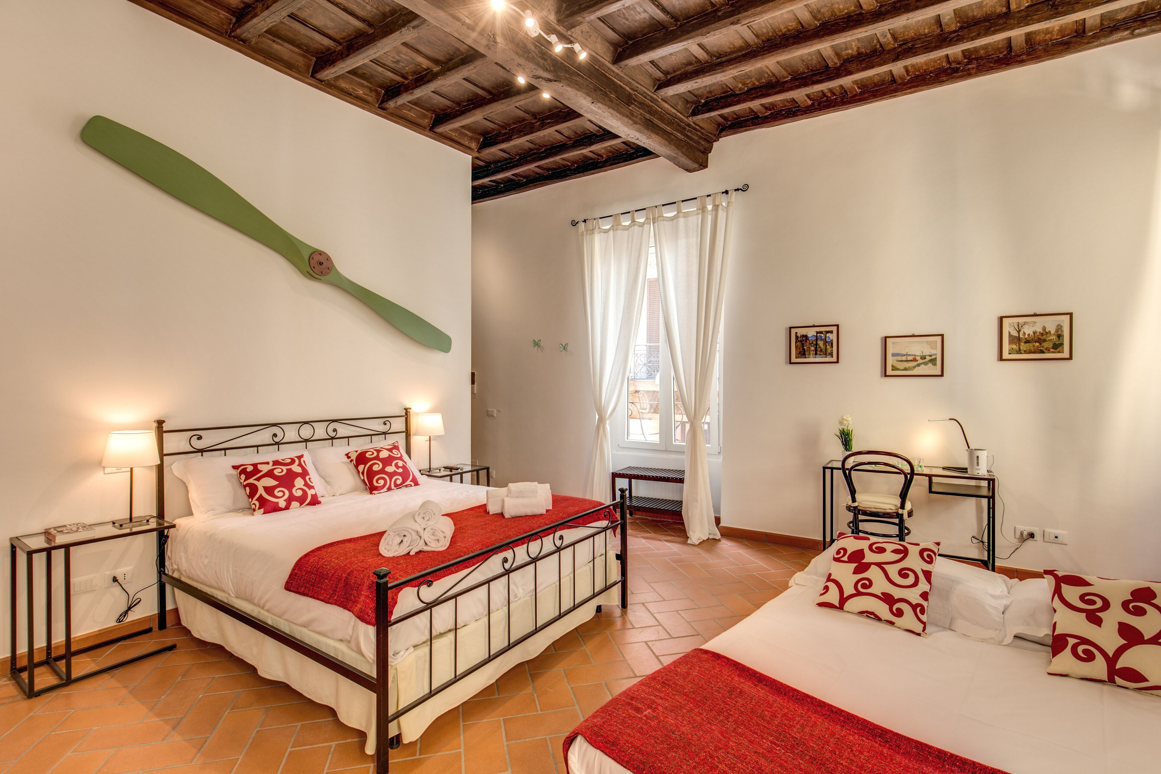 Un dormitorio con cama, mesitas de noche, un escritorio y una silla.