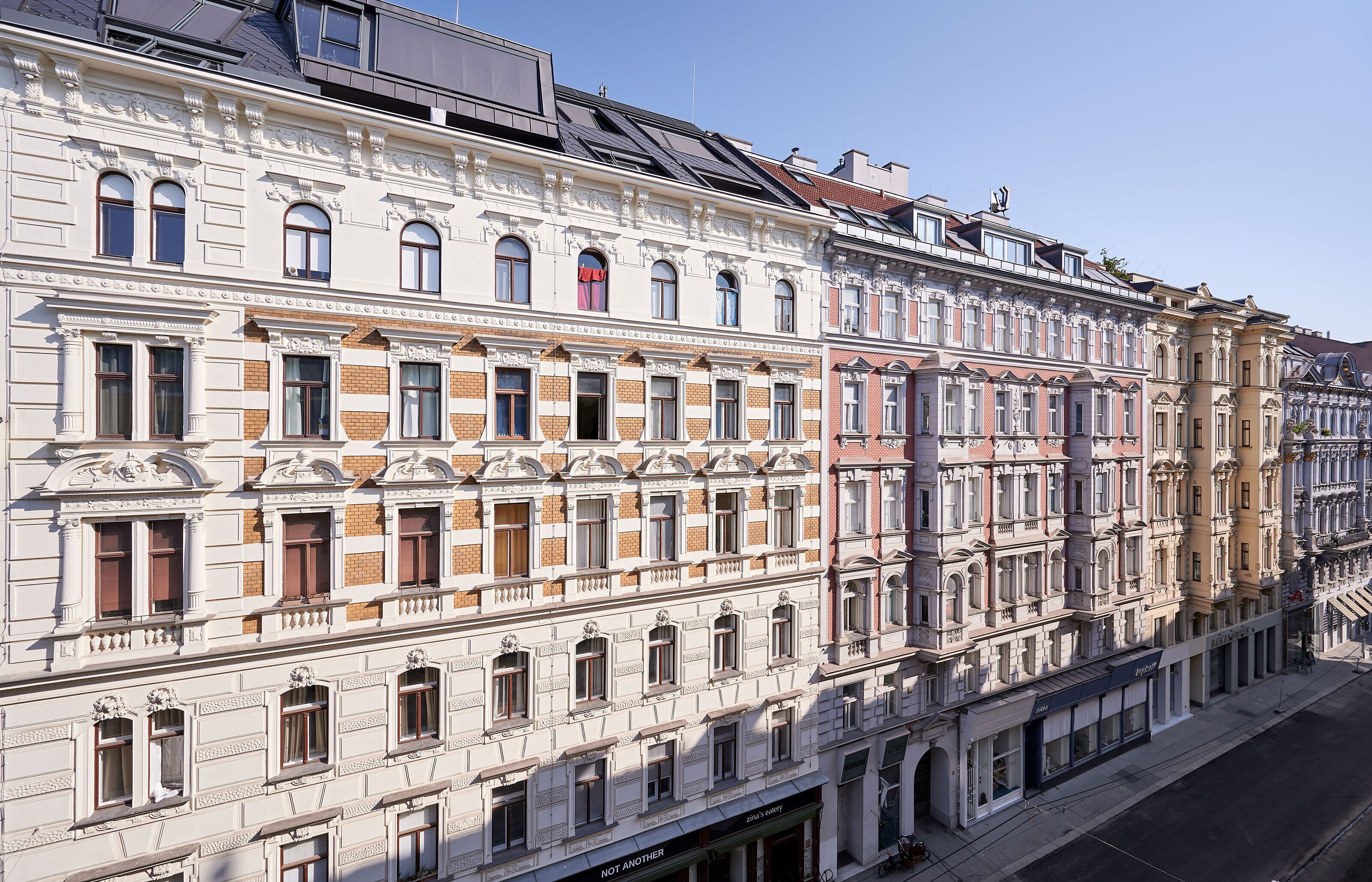 Ein mehrstöckiges Gebäude mit aufwendigen architektonischen Details, darunter Säulen und dekorative Verzierungen.